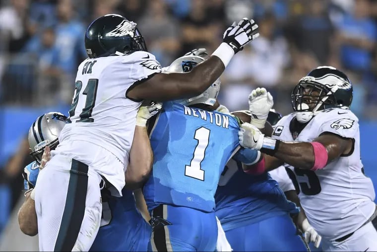 Panthers quarterback Cam Newton, being sacked here by Fletcher Cox (left) and Brandon Graham last year, is 2-2 all-time against the Eagles.