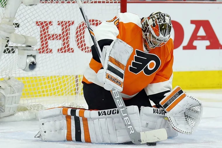 Michal Neuvirth stops the puck with his stick against the Washington Capitals' during the second period.