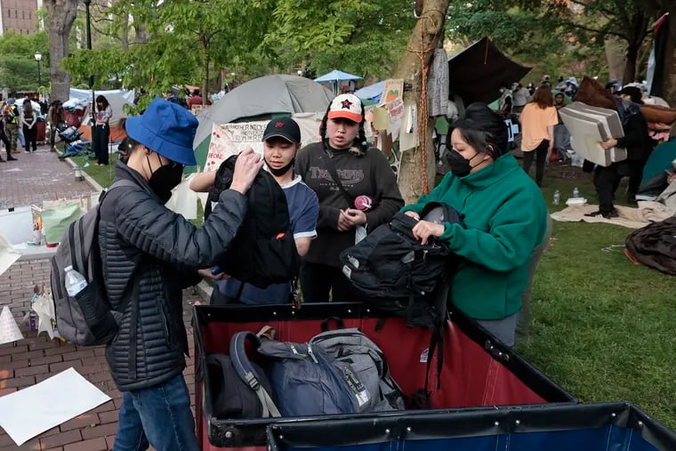 People staying at the encampment, who agreed to be arrested if need be label their belongings and put them in the bins for safe keeping on College Green at the University of Pennsylvania campus on Sunday.