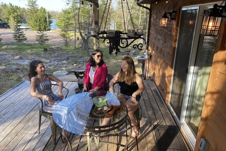 Barbara Boyer (center) enjoys time on the deck she built with help from daughters, Bella, 13 (left) and Dorothy, 16, at their Lake Harmony vacation home in the Poconos. The deck was built in using wood salvaged from the original lake cottage.