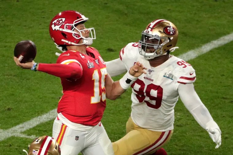 Chiefs quarterback Patrick Mahomes (15) throws a fourth-quarter pass to Tyreek Hill as the 49ers' DeForest Buckner (99) attempts to defend.
