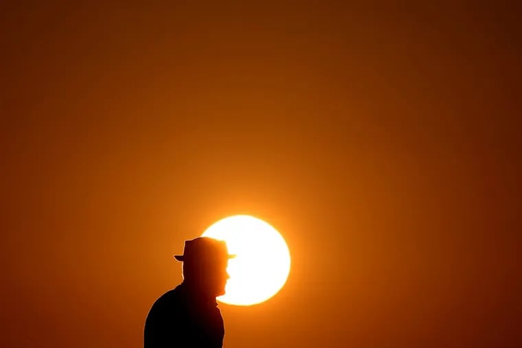 Visitors to Angels Gate Park in Los Angeles’ San Pedro neighborhood watch the setting sun under a fiery canopy of clouds at the end of a hot day in Southern California on Friday, July 7, 2017.