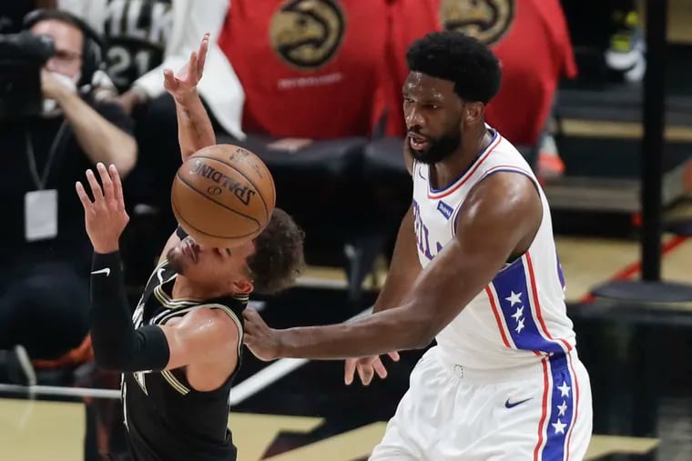 Sixers center Joel Embiid fouls Atlanta Hawks guard Trae Young during the first quarter in Game 4.