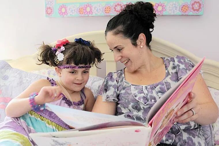 Rachel Simpson reads the children's book Purplicious to her 5-year-old daughter Rebecca in the daughter's room in Cherry Hill August 26, 2013.  (Clem Murray/Staff Photographer)