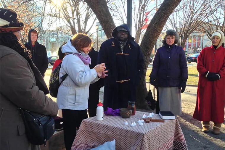 Frigid temperatures can't keep Rev. Violet Little (center, in blue jacket) from leading her monthly communion service for the homeless on the Parkway.