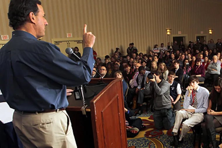 Rick Santorum talks with college students in Concord, N.H. Though he sprinkled his Iowa speeches with his social views, he focused on the economy in New Hampshire until he was drawn into a debate. (Jim Cole / Associated Press)