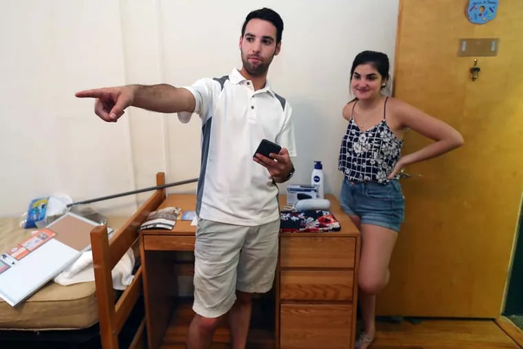 Brett Barry goes over the belongings that he and his brother Sean brought up for Isabela Garcia, from Panama, at an apartment at St. Joseph's University. The Barry brothers do the sweating so that students don't have to.