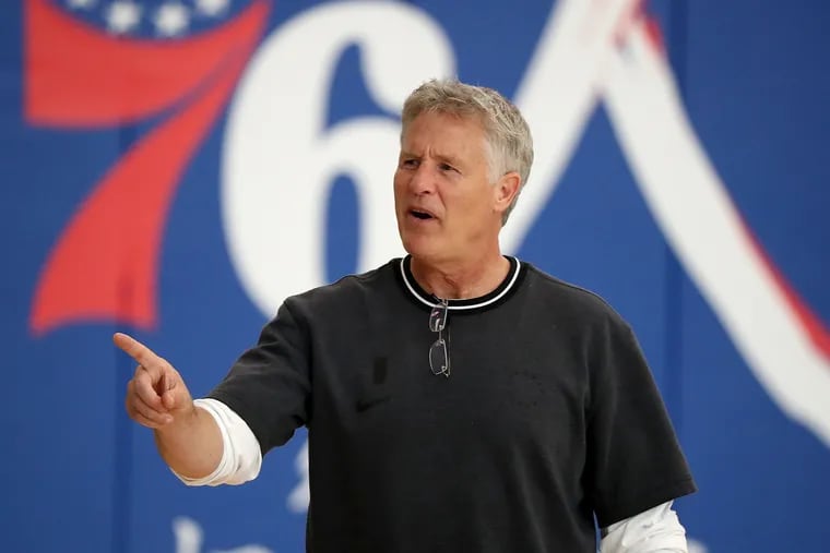 Sixers head coach Brett Brown walks over to talk with reporters during Sixers practice in Camden on Tuesday.