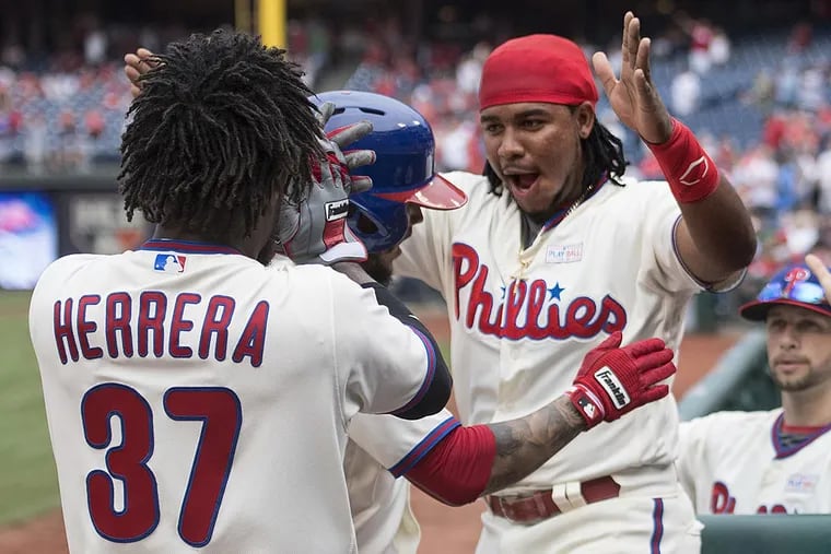 Odubel Herrera (left) and Maikel Franco congratulate teammate Freddy Galvis after he hit a home run.