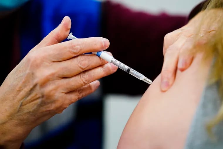 A health worker administers a dose of a COVID-19 vaccine during a vaccination clinic at the Keystone First Wellness Center in Chester, Pa., in December.
