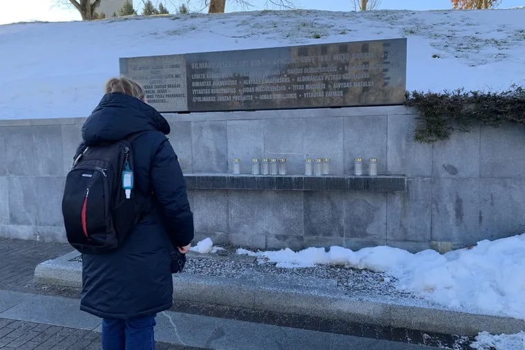 A Lithuanian woman reads the memorial stone to 14 citizens who were killed by Soviet bullets and tanks on Jan. 13, 1991, while defending the TV tower in the capital, Vilnius, against Moscow's efforts to overturn Lithuania's declaration of independence from the Soviet Union.