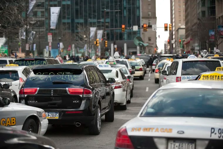 Taxicabs and Uber Black cars were parked in front of Philadelphia's City Hall.