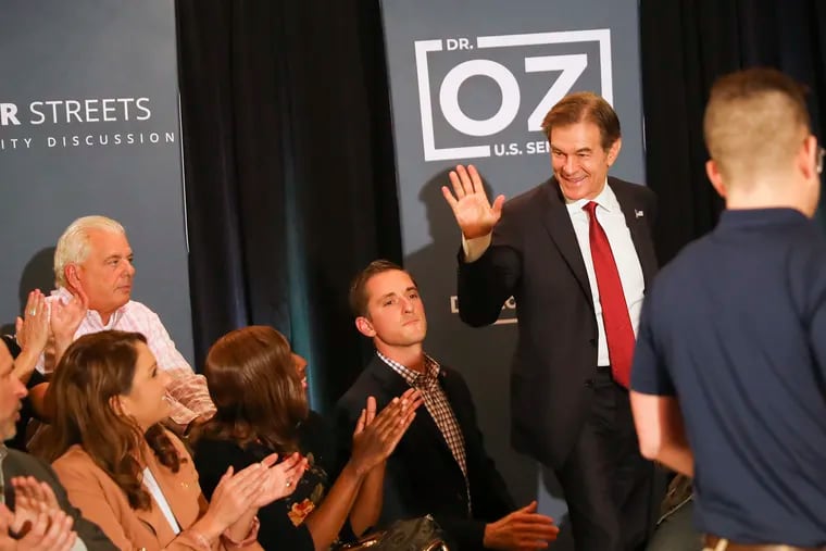 Mehmet Oz waving as he enters a community roundtable discussion at Galdos Catering and Entertainment in South Philadelphia on Oct. 13.