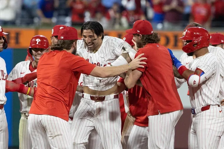 Nick Castellanos, center, swarmed by his Phillies teammates after hitting a walk-off double in the 10th inning.