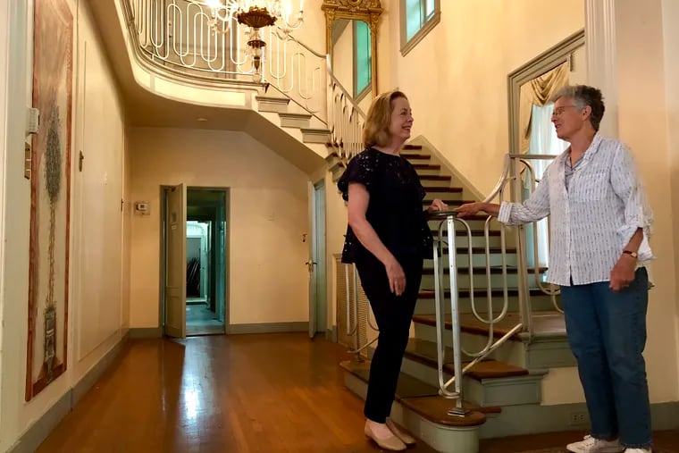 Tish Long (left), the president of the Willows Park Preserve, and Sara Pilling, the granddaughter of Philadelphia architect Charles Barton Keen, who designed the Willows mansion more than a century ago, stand for a photo at the staircase in the Willows mansion in Villanova, Pa., on Wednesday, June 13, 2018.