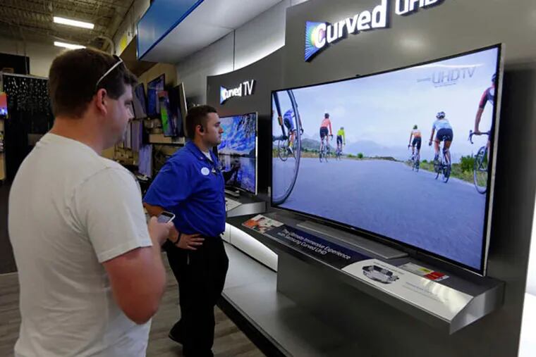 Shopping for a TV at a Best Buy store in Greenwood, Ind. Shown is a Samsung 78-inch curved television. (Michael Conroy / AP)
