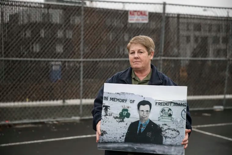 Betty Adams holds a photo of a mural honoring her son Freddy, who was killed in 1993 at age 16. The mural will be restored as the Swimmo, the beloved neighborhood pool, and the local rec center where Freddy worked, are repaired as part of the city's Rebuild efforts.