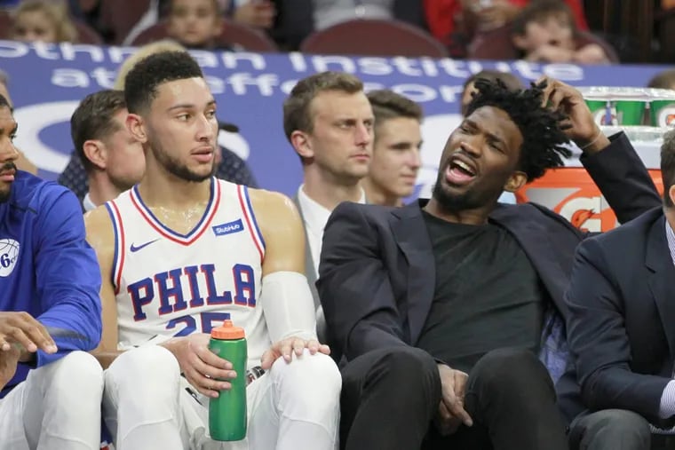 Joel Embiid, here sitting next to Ben Simmons (left) during a preseason game in October, will be doing a lot more sitting tonight.