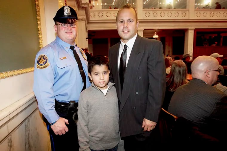 Tommy "TJ" Ramos, 9, a catcher with the Torresdale Boys Club suffered a heart attacked but was aided by off duty officers John Callahan, (left) and John Pasquarello. Photograph in city council on Thursday, December 5, 2013. The two officers were in council to accept resolution from 6th District Councilman Bobby Henon. ( ALEJANDRO A. ALVAREZ / STAFF PHOTOGRAPHER )