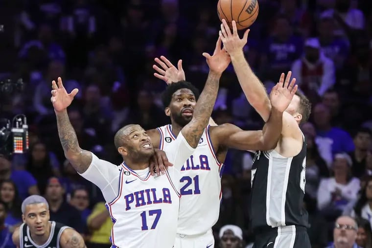 Sixers forward P.J. Tucker and center Joel Embiid battle for a rebound with San Antonio Spurs center Jakob Poeltl in the first half of a game at the Wells Fargo Center.