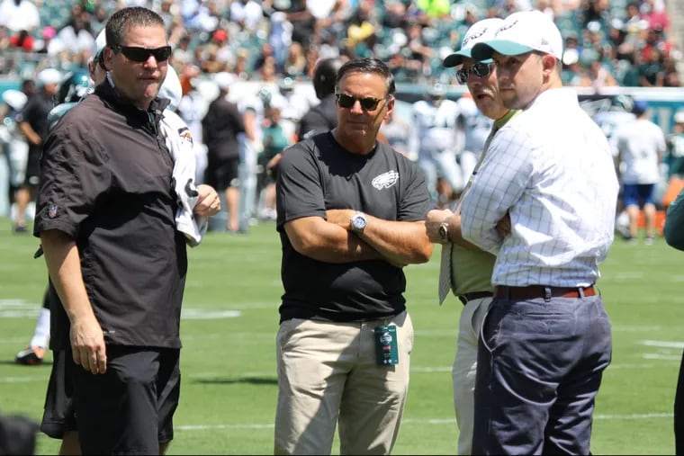 Peter DeLuca (center) no longer is the Eagles' head team physician. Head athletic trainer Chris Peduzzi (left), resigned in February.