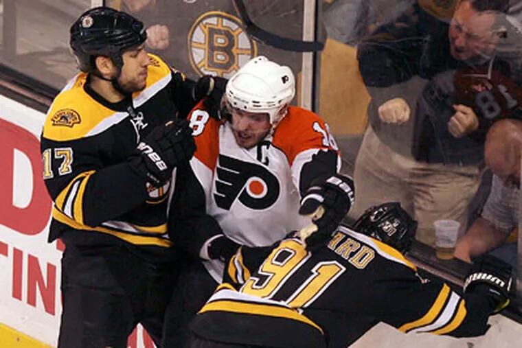 Boston’s Marc Savard and Milan Lucic tag-team Mike Richards in Game 5. (Yong Kim / Staff Photographer)