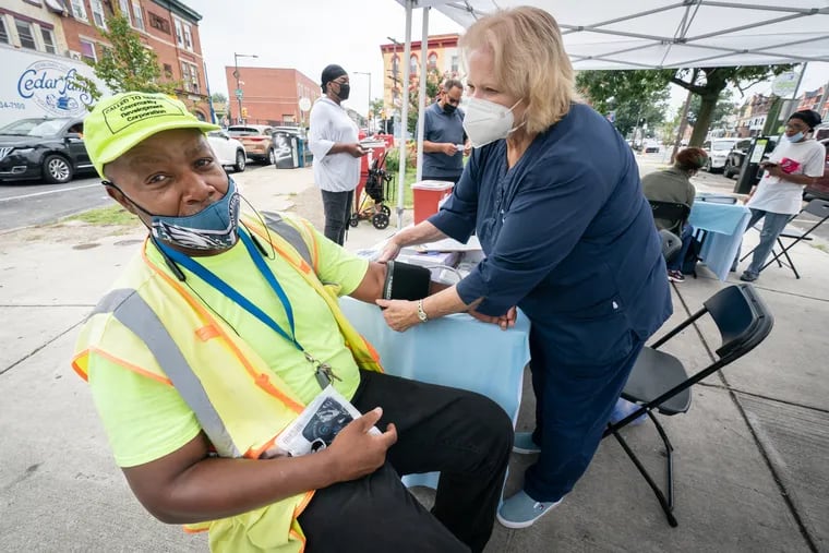 Robert White, left, has his blood pressure taken by Barbara Hitchens, Nurse Practitioner, from Miriam Medical Clinics, MZT, at Butler Triangle, Broad and Germantown Ave, in Philadelphia, Monday, August 1, 2022.