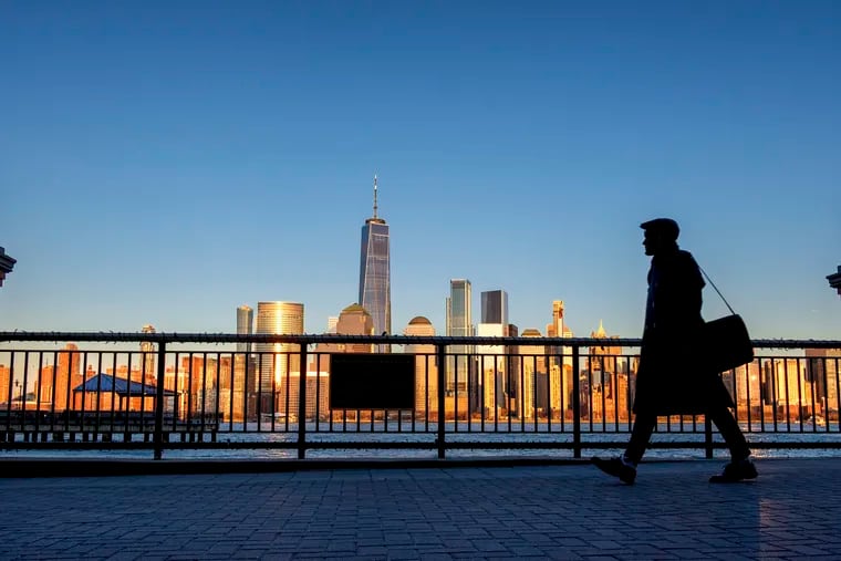 FILE - In this March 26, 2019 file photo, an evening commuter is silhouetted against the glistening New York City skyline at sunset as he walks along Hudson River shoreline in Jersey City, N.J. On Wednesday, April 17, the Federal Reserve releases its latest "Beige Book" survey of economic conditions. (AP Photo/J. David Ake, File)