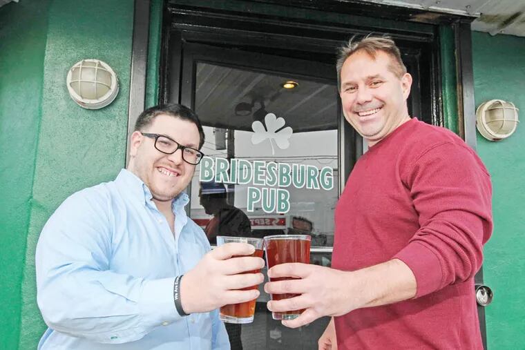 Thomas Sheridan a local guy, brews his Do Good United Ale in Port Richmond & only supplies neighborhood bars like the Bridesburg Pub. Percentage of profits go to charities, hence the Do Good brand. Thomas Sheridan, left  with Bridesburg Pub owner Bob McMaster,  Thursday December 4, 2014. (Steven M. Falk / Staff Photographer)