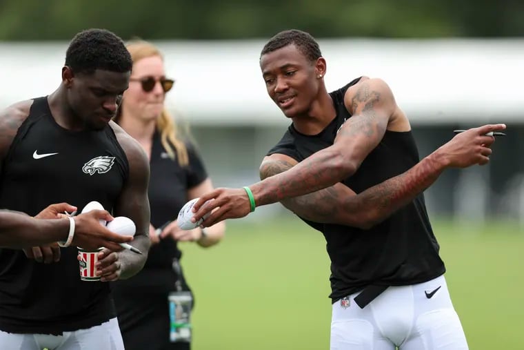Eagles wide receivers Jalen Reagor (left) and DeVonta Smith signing autographs after a joint practice with the New England Patriots at the NovaCare Complex last week. They're the team's most talented young wideouts since DeSean Jackson and Jeremy Maclin in 2009.