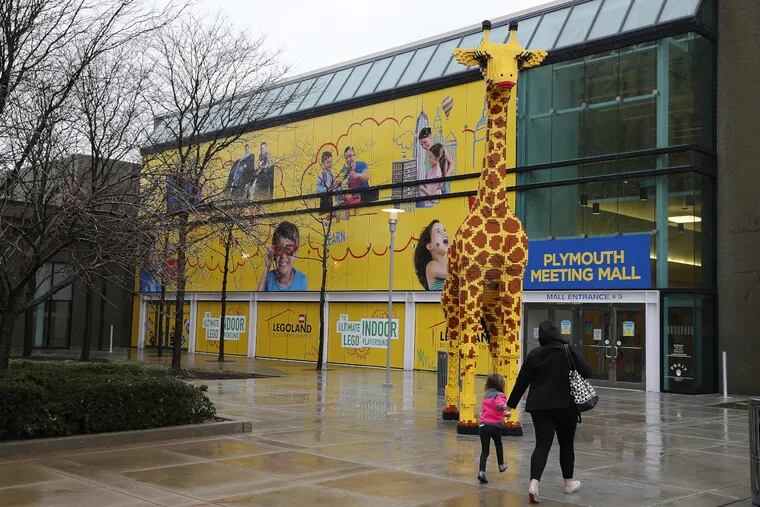 Visitors pass a large Lego giraffe as they make their way to the grand opening of Legoland Discovery Center in the Plymouth Meeting Mall in Plymouth Meeting, PA on March 31, 2017.