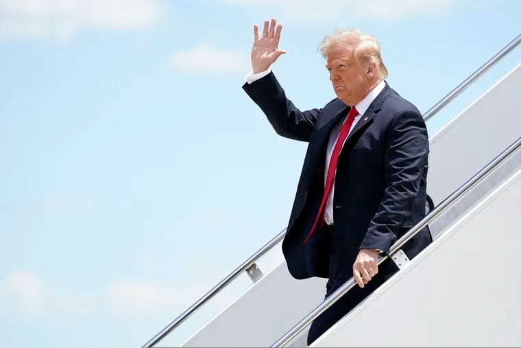 President Donald Trump waves as he arrives on Air Force One at Austin Straubel International Airport in Green Bay, Wis.