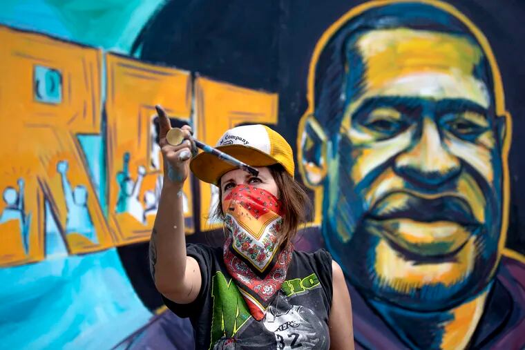 Greta McClain and two other artists paint a mural of George Floyd on the wall of Cup Foods in Minneapolis during a third day of protests following Floyd's death while in police custody, on Thursday, May 28, 2020. Floyd, 46-year-old Minneapolis resident was an early member of legendary Houston hip-hop innovator DJ Screw's crew.