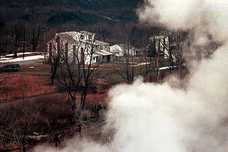 Smoke from an underground fire billows over the few remaining homes in Centralia, a former coal-mining town, in 2001. (Inquirer archive)