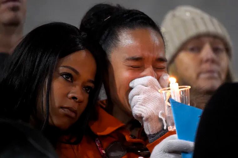 A woman cries as she and others gather for a candlelight vigil at San Manuel Stadium in San Bernardino. The service, a day after the massacre, was in remembrance of the 14 killed.