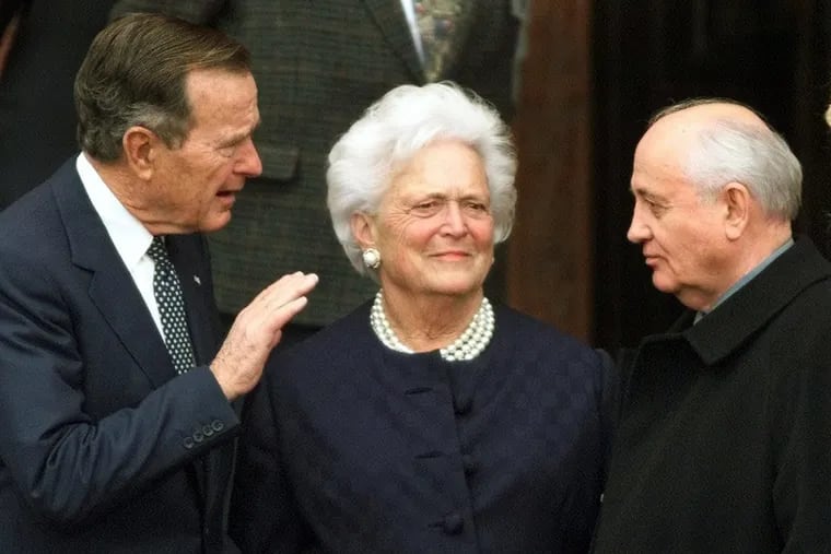 In this Nov. 8, 1999, file photo, former U.S. President George H.W. Bush, left, chats with former Soviet leader Mikhail Gorbachev, right, as Barbara Bush looks on.