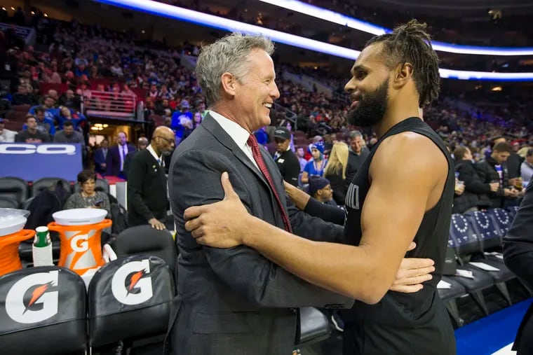 Head Coach Brett Brown, left, of the Sixers greets Patty Mills of the Spurs before their game at the Wells Fargo Center on Jan 3, 2018. Brown was once an assistant coach with the Spurs.