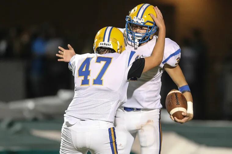Downingtown East’s Tim Aivado celebrates his TD run with teammate Jack O’Reilly against Bishop Shanahan on Sept. 22.