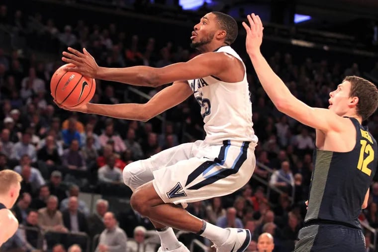 Mikal Bridges, left, of Villanova goes by Matt Heidt of Marquette during the 1st half in the Big East Tournament at Madison Square Garden on March 8, 2018.