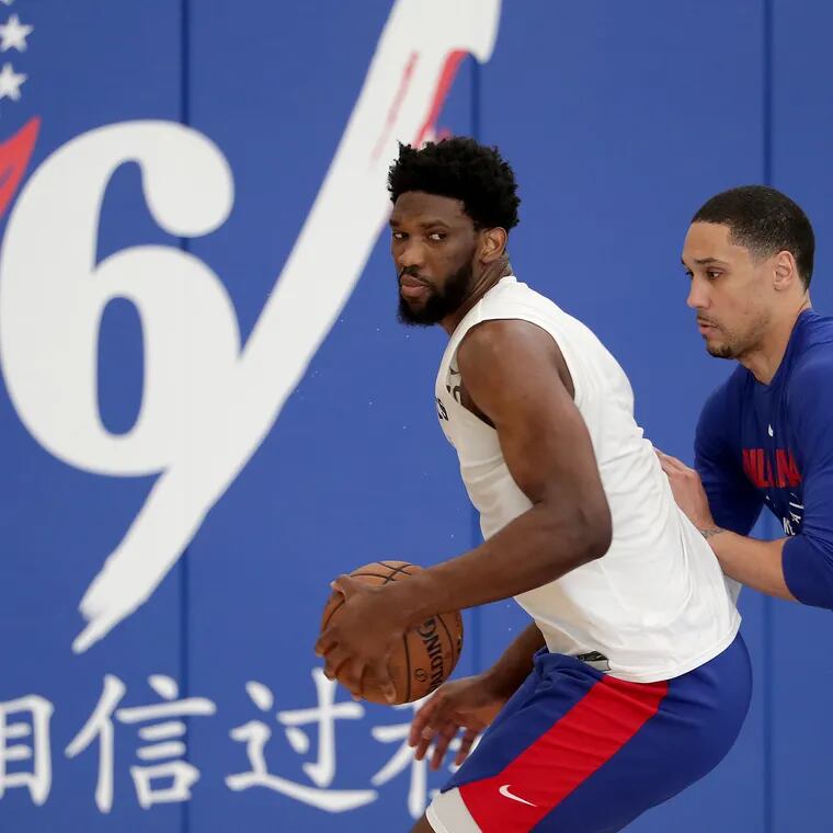 Dwayne Jones (right) working with 76ers star Joel Embiid in 2019.