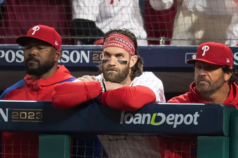Bryce Harper looks on  from the dugout as the Diamondbacks celebrate their win in Game 7.