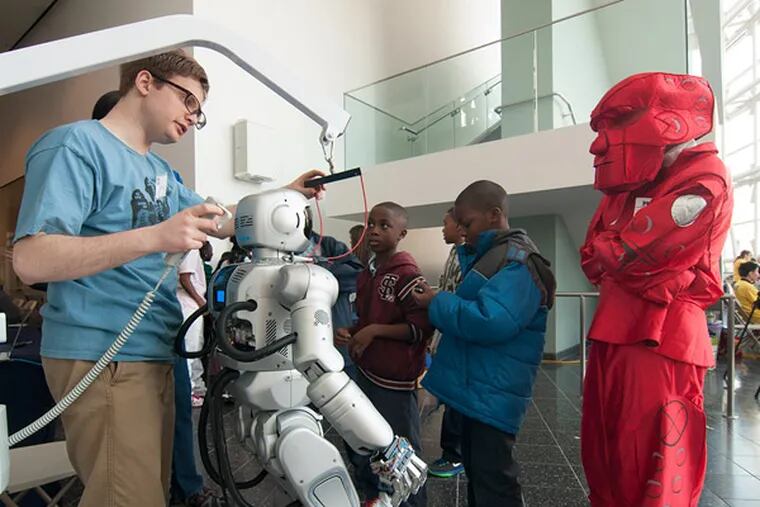 William Hilton of Drexel University’s Music and Entertainment Technology Laboratory adjusts his robot, which entertained students from Benjamin Franklin Elementary School with a kung fu presentation. (Patrick McPeak / Staff Photographer)