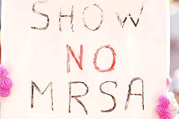 Fan holds up a "Show no MRSA" sign. (Ron Cortes/Staff Photographer)