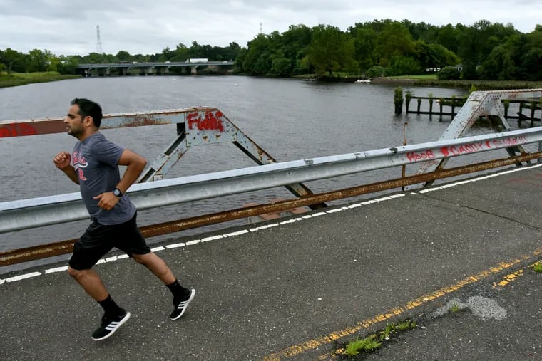 Sunder Shahani of Mt. Laurel jogs on the Centerton Bridge in August. The Burlington County span over the Rancocas Creek was closed to vehicular traffic in 2015. Some local residents would like to see it rebuilt, while others support tearing it down to make way for a pedestrian-only bridge.