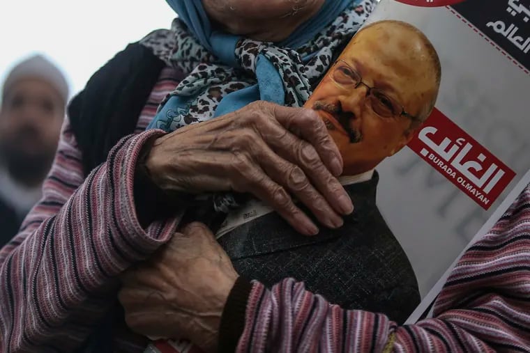 A woman holds a poster during the funeral prayers in absentia for Saudi writer Jamal Khashoggi who was killed last month in the Saudi Arabia consulate, in Istanbul, Friday, Nov. 16, 2018.
