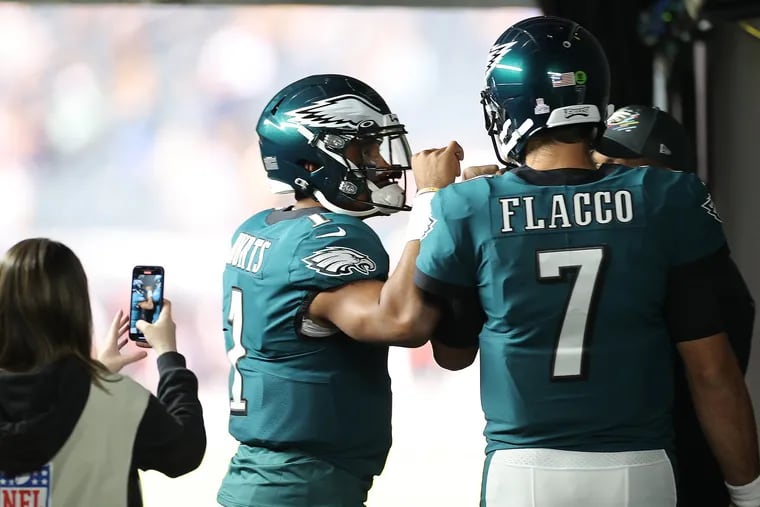 Eagles starting quarterback Jalen Hurts fist-bumps Joe Flacco before taking the field. They should switch roles.