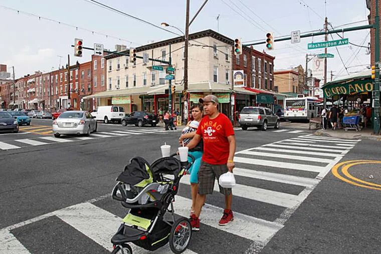 A couple cross the street at the busy intersection of 9th and Washington Avenue.  ( Michael Bryant / Staff Photographer )