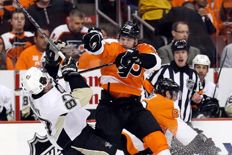 The Flyers' Claude Giroux (28) takes down the Pittsburgh Penguins' Sidney Crosby (87) in this file photo. It would be a shame if theses bitter cross-state rivals were in different divisions and did not meet this season.