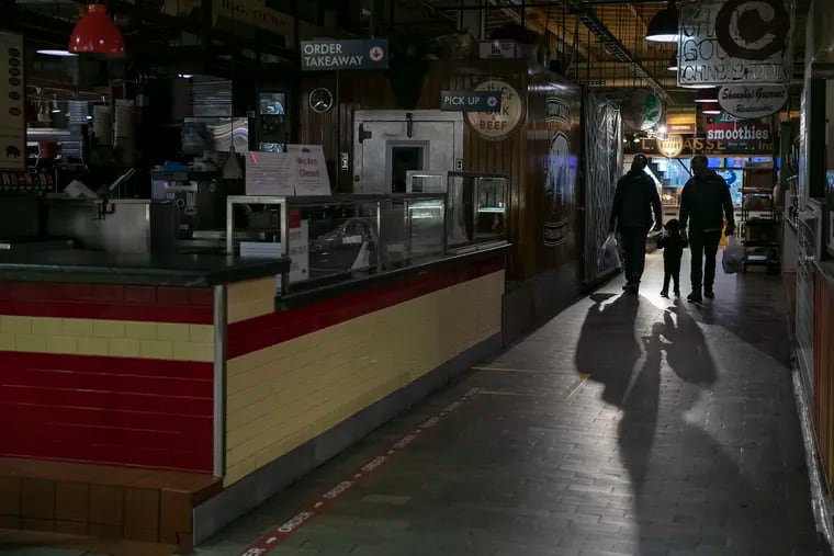 Customers walk through an emptier than normal Reading Terminal Market on Thursday, March 19, 2020.