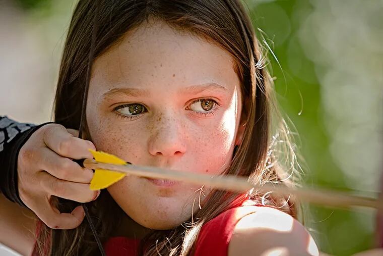 Samantha Klein, draws back her arrow and takes aim at the target on the archery range at Burn Brae Camp in Upper Dublin on July 24, 2015. Burn Brae Camp in Upper Dublin which is offering an old-school camp experience that includes a focus on vintage sports with not a electronic screen in site. ( ED HILLE / staff photographer )